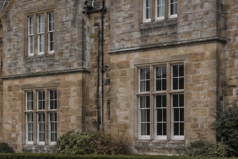 Close view of dressed sandstone ashlar with carved window surrounds and a moulded string course on a traditional Scottish building